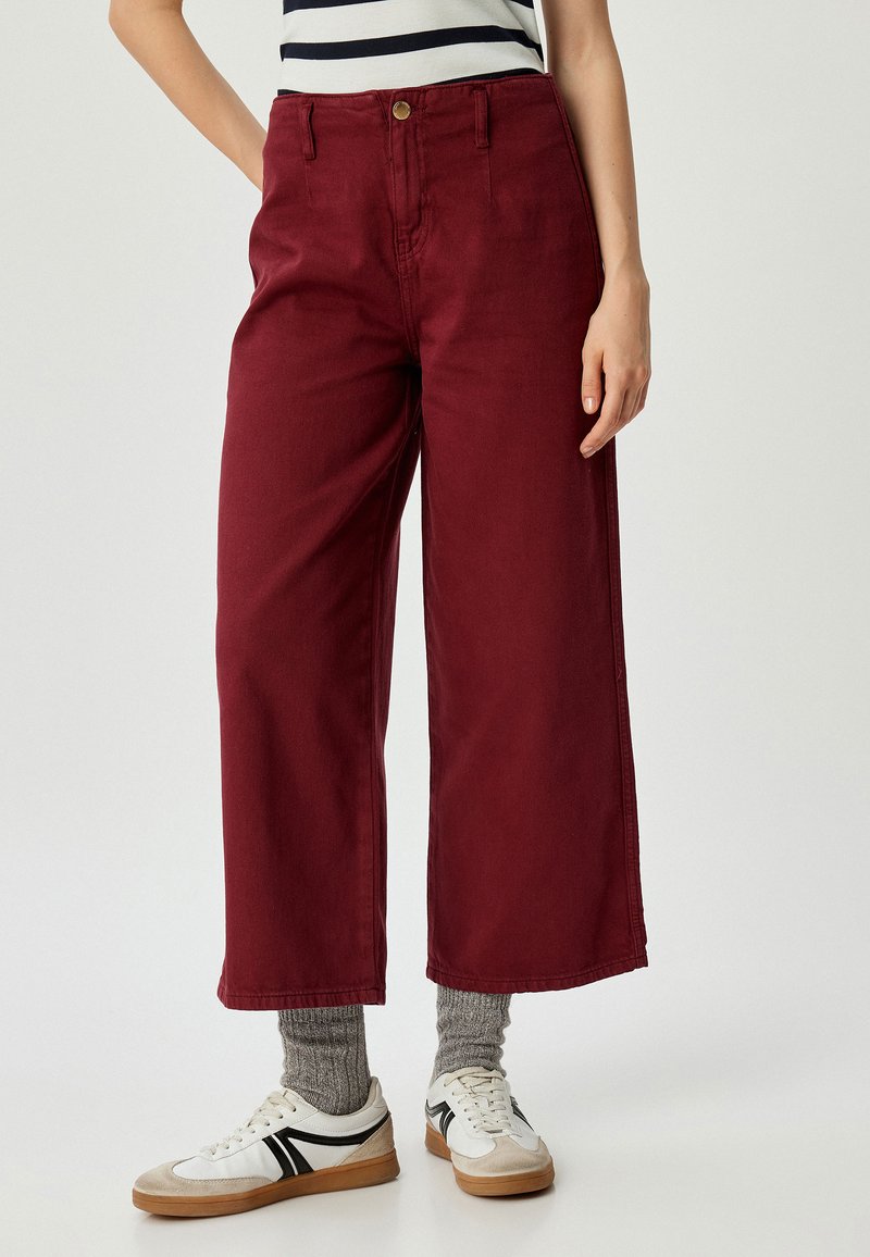 Bordeaux brede pijpenbroek met hoge taille, voorzien van een knoopsluiting aan de voorkant, zijzakken en een soepele, duurzame stof.