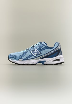 hele sinine New Balance jooksujalats valge tallaga, siniste ja hõbedaste detailidega ning küljele kinnitatud "N" logoga, nähtav jalatsi välimine külg.