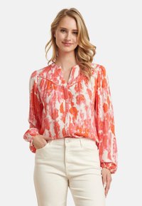 Farbenfrohe Bluse in Orangetönen und Weiß, mit Knopfverschluss vorne, langen Ärmeln mit elastischen Bündchen und einem weichen, glatten Stoff.