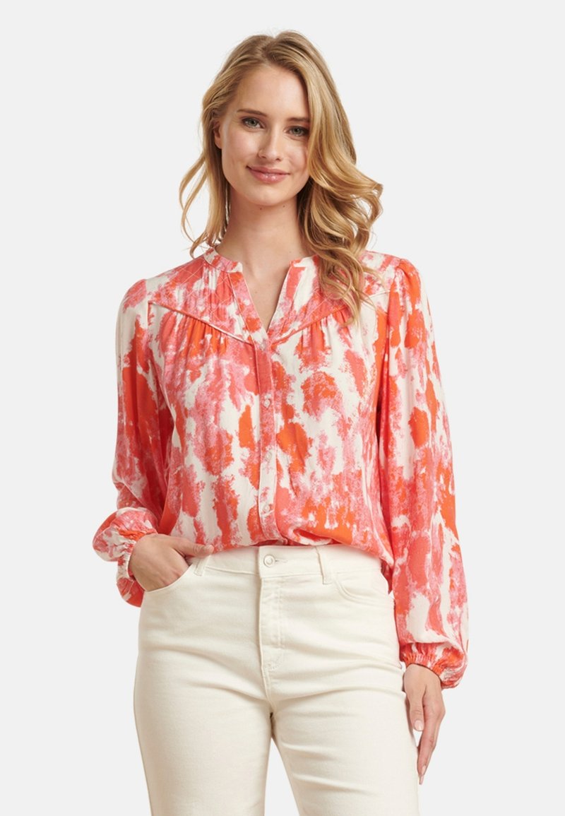 Farbenfrohe Bluse in Orangetönen und Weiß, mit Knopfverschluss vorne, langen Ärmeln mit elastischen Bündchen und einem weichen, glatten Stoff.