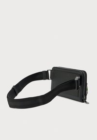 Portafoglio nero con cerniera, finitura testurizzata, dotato di tracolla staccabile e dettagli in metallo. Design compatto a rettangolo, adatto per l'essenziale.