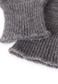 Tessuto lavorato a maglia grigio con una texture a coste e una finitura morbida, che mostra due bordi sovrapposti. Il materiale appare spesso e caldo.
