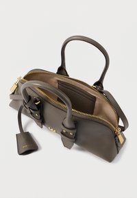 Γκρι δερμάτινη τσάντα χειρός με διπλούς χειρολαβές, χρυσό φερμουάρ, εσωτερική τσέπη και αποσπώμενη ετικέτα. Λείο υλικό και μινιμαλιστικός σχεδιασμός.