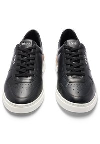 Sneaker in pelle nera con dettagli perforati, suole in gomma bianca, lacci neri e branding BOSS sulla linguetta e sugli accenti laterali.