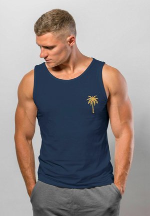 Marineblaues Tanktop aus glattem Stoff, mit einem kleinen goldenen Palmenbaum-Graphic auf der linken Brust. Klassischer Schnitt mit breiten Trägern.