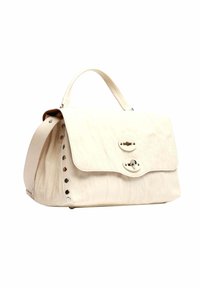 Borsa a mano in pelle color crema con manico superiore, chiusura a patta e borchie metalliche decorative lungo il lato.