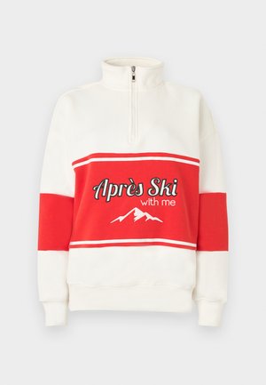 Hanorac alb cu guler înalt, cu dungi orizontale roșii și textul "Apres Ski with me", plus un desen de munte alb.