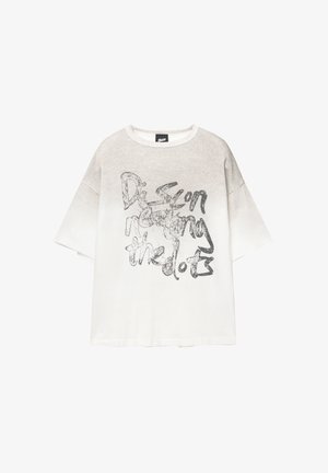 T-shirt bianco oversize con un design a gradiente, con testo nero "Connecting the Dots" in uno stile scritto a mano sulla parte anteriore.