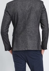 Szary, teksturowany blezer o dopasowanym kroju, z pojedynczym rozcięciem z tyłu oraz długimi rękawami ozdobionymi guzikami.