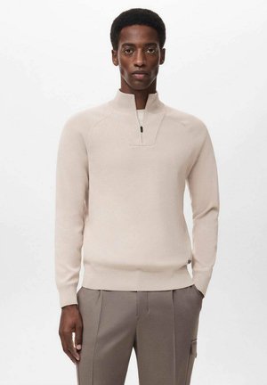 Light beige pullover with a half-zip collar, made from a smooth knit material. Features raglan sleeves and a fitted waistband.