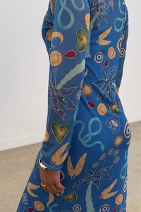 Garšīga zila kleita ar krāsainiem, dažādiem rakstiem, tostarp tauriņiem, sirds formām un dabīgām norisēm, ar garām piedurknēm un pieguļošu dizainu.