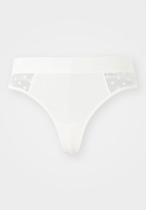 Witte string gemaakt van een zachte, gladde stof. Heeft doorzichtige mesh zijkanten met een stippenpatroon. Elastische tailleband bedrukt met "HUGO."