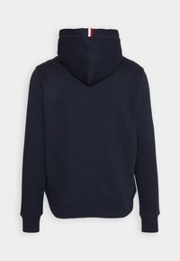 Marineblauwe hoodie met lange mouwen, geribbelde manchetten en een capuchon met een klein rood-wit streepdetail in het midden bovenaan.