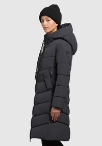 Czarna kurtka puchowa z kapturem, z pikowanym wzorem, z przodem na zamek błyskawiczny, boczną kieszenią oraz logo na uchwycie zamka.