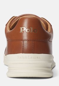 Bruna lädersneakers med vadderad krage, guld "Polo"-logotyp och krämfärgad gummisul med texturerad detaljering.