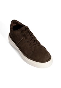 Braune Wildleder-Sneaker mit abgerundetem Zehenbereich, weißer Gummisohle und Schnürdesign. Verfügt über subtile Ziernähte und eine strukturierte Oberfläche.
