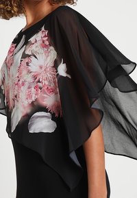 Czarny, przezroczysty kimono z kwiatowym wzorem w kolorze różowym i białym, z szerokimi rękawami i zwiewnym, lekkim fasonem.