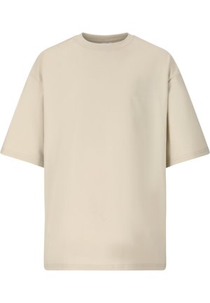 Beige oversized T-shirt med korte ærmer, rund hals og diskret tonet logo på brystet, vist på en ensartet hvid baggrund.