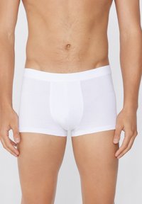 Bóxer blanco de algodón suave, con un ajuste ceñido, cinturilla elástica y bolsa frontal para soporte. Diseño minimalista.