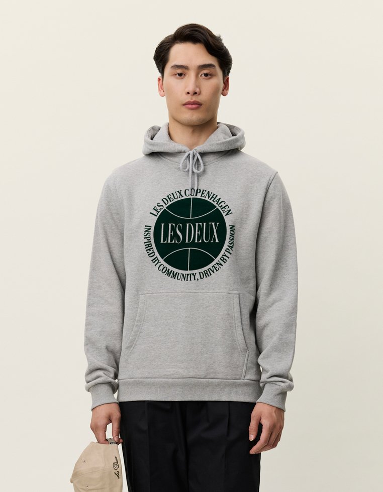 Γκρι φούτερ με κουκούλα από μαλακό ύφασμα, featuring κυκλικό λογότυπο σε πράσινο χρώμα με το κείμενο "LES DEUX COPENHAGEN". Περιλαμβάνει μπροστινή τσέπη καγκουρό.