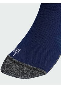 Στρατιωτικού μπλε κάλτσα με υφή πλέξης στην επάνω πλευρά και πιο σκούρο, στικτό δάκτυλο. Διαθέτει λευκό λογότυπο στο πλάι και ενισχυμένη φτέρνα.