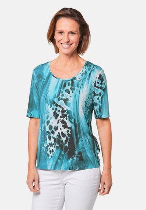 Korte mouwen top in turquoise, zwart en wit met abstract patroon. Heeft een ronde halslijn en een gladde, lichte stof.
