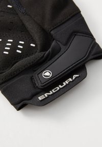 Zwarte fietshandschoen met een gepolsterde palm, geperforeerde details en versterkte stiksels. Inclusief een klittenbandsluiting en logo-accent.