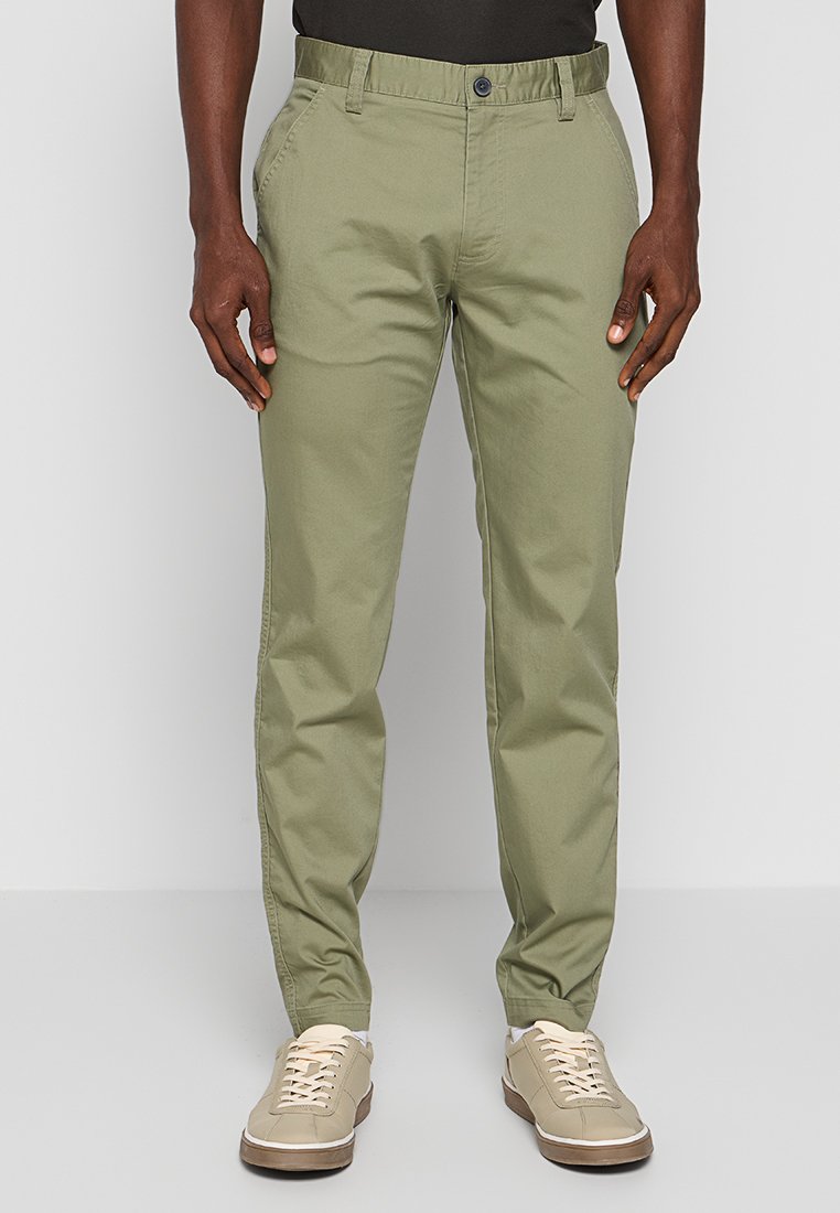 Lichtgroene chino's met een rechte pasvorm, gemaakt van katoen. Voorzien van schuine voorzakken en een knoopsluiting bij de tailleband.