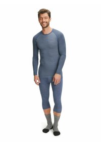 Set di base termico da uomo; maglia a maniche lunghe e leggings aderenti in un tessuto blu melange con un motivo testurizzato, abbinati a calzini grigi.
