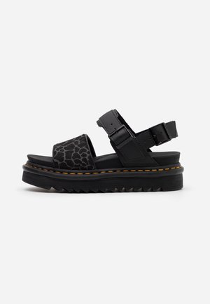 Sort platformsandal med tyk rillede sål, to justerbare spænderem og en bred frontrem med diskret dyreprint.