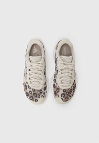 Baskets de sport beige avec un motif léopard, tige en mesh et semelle de couleur claire. Dotées de lacets et d'une languette rembourrée.