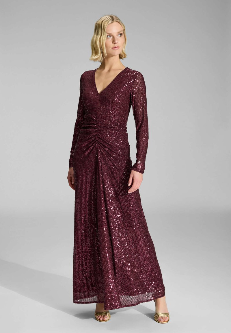 Robe en sequins bourgogne avec manches longues, décolleté en V et détail de taille froncée. Conception longue jusqu'au sol avec une texture lisse et scintillante.