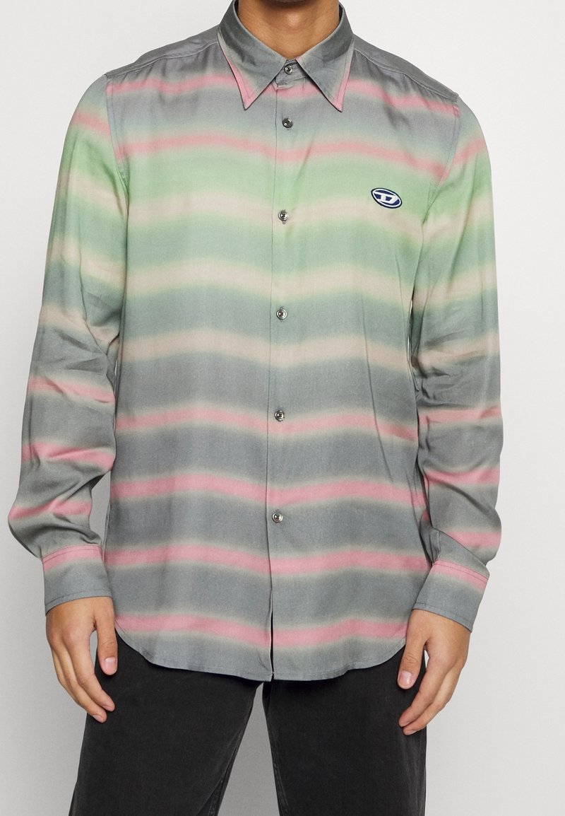 Camisa de botones en tela ligera, con franjas horizontales en verde, rosa y gris, y un pequeño logo en el pecho.