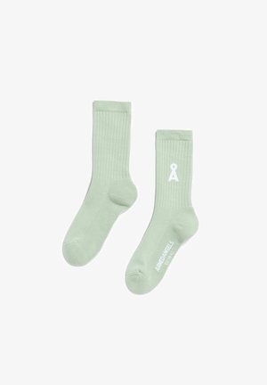 Grüne gerippte Socken aus weichem Material mit einem weißen Logodetail. Das Design umfasst eine bequeme Bündchenpartie und eine Standard-Sockenform.