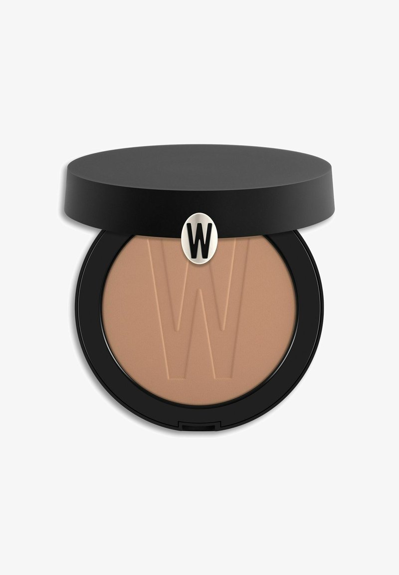 Cipria compatta in un astuccio circolare nero, caratterizzata da una polvere beige liscia con un logo 'W' in rilievo al centro. Finitura satinata.