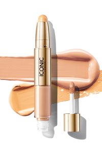 Flytende concealer i en gyllen tube med en avrundet applikator. Følger med en jevn, ferskenfarget swatch på en hvit bakgrunn.