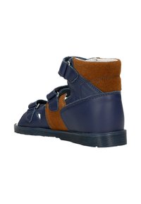 Scarpa alta in pelle blu navy con accenti in suede marrone, due cinturini regolabili e suola texture, progettata per comfort e supporto.