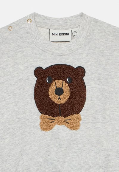 Grijze sweatshirt met een textuurafdruk van een bruine beer met een tan strik. Inclusief twee gouden drukknoopjes op de schouder.