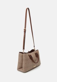 Sac fourre-tout au motif géométrique beige avec des poignées en cuir brun et une bandoulière réglable ; accents en métal doré.