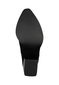 Suela de zapato negra con un diseño suave y redondeado. Presenta ribetes texturizados para mejorar el agarre y un tacón cuadrado y robusto. Fabricada con materiales duraderos.