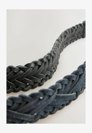 Cinturón de cuero trenzado negro con un diseño texturizado. La superficie presenta un ligero desgaste, lo que resalta la artesanía y la durabilidad.