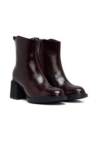 Stivaletti borgogna in materiale lucido, con zip frontale, tacco quadrato nero e finitura testurizzata.