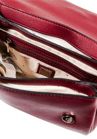 Borsa a tracolla in pelle testurizzata color bordeaux con finiture dorate, dotata di chiusura con zip, molteplici scomparti interni e etichetta con logo.