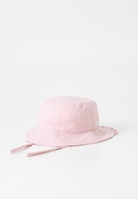 Rosa bucket cap i mjukt tyg, med en vit logotyp och dragsnöre, samt ett brett, platt brätte för solskydd.