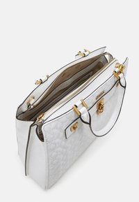 Weißer gesteppter Handtasche mit goldenen Beschlägen, doppelten oberen Griffen und offenen Reißverschlusstaschen, die das beige Innenfutter zeigen.