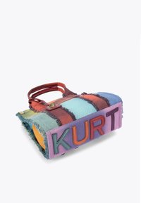 Multikleurige denim tas met rafelige randen. Voorzien van gedurfde "KURT" letters in verschillende kleuren en twee korte handvatten om te dragen.