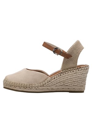 Sandale espadrille beige à talon compensé avec bout fermé, talon en jute tressé, dos tissé et bride de cheville marron avec boucle argentée.