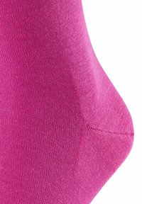 Calzino rosa in cotone con una texture liscia, tessuto a coste e cucitura rinforzata sulla punta, inclinato leggermente per mostrare chiaramente la sua forma.