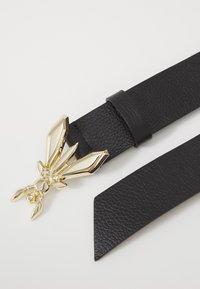 Cintura in pelle nera con una fibbia a chiusura a gabbiano in metallo dorato lucido. La fibbia presenta un design scultoreo dettagliato.