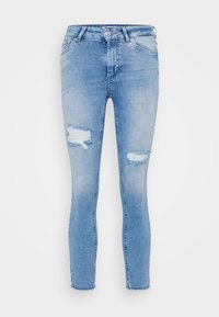 Light wash denim skinny jeans with ripped detailing on knees, zipper fly, and five-pocket design. Distressed texture, frayed hems.